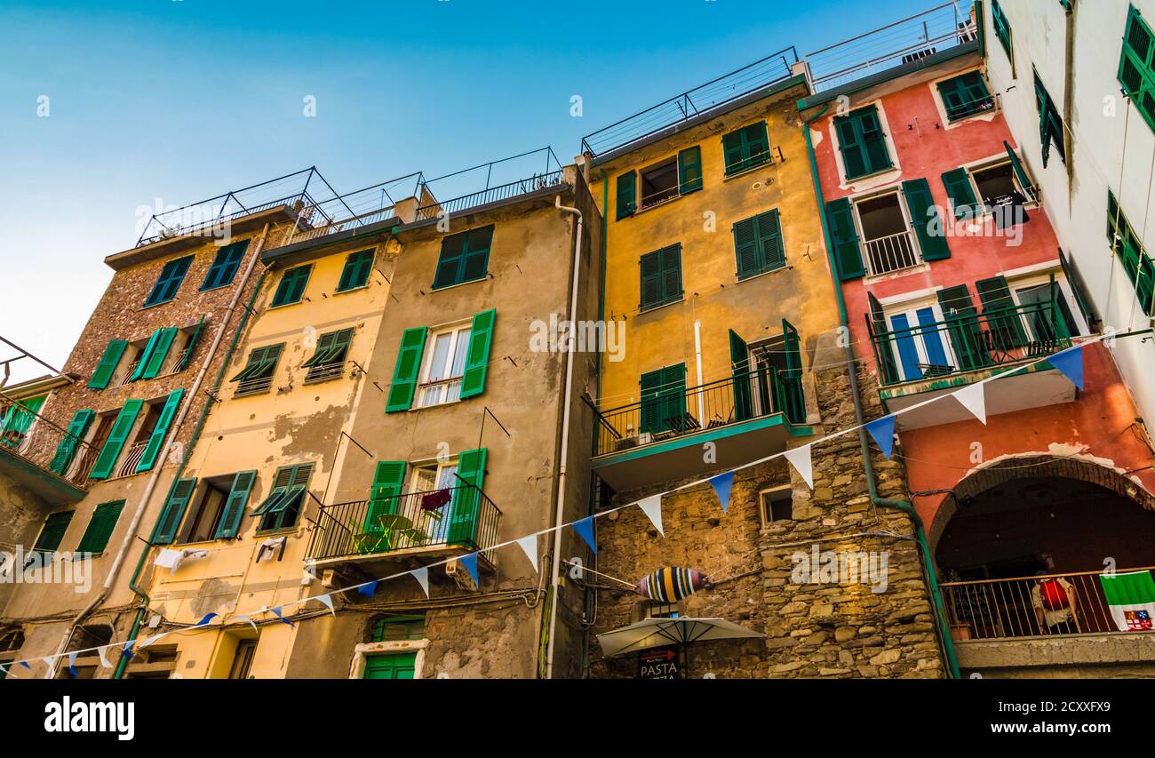 Great close-up view of the historic colourful tower houses with typical green louvered window shutters on the road Via San Giacomo in Riomaggiore, the... Stock Photo