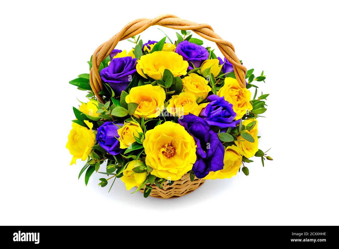Basket with yellow and blue flowers on isolated white background. Bouquet of yellow and purple roses. Beautiful flowers in a wicker basket. Bouquet of Stock Photo
