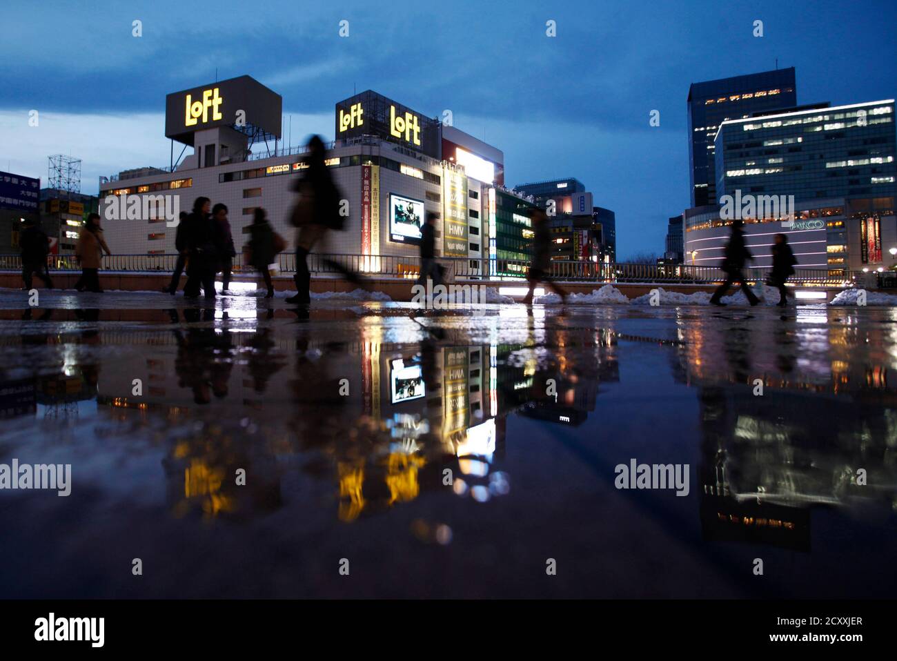 Pedestrians Are Reflected In A Puddle In Front Of Sendai Train Station Miyagi Prefecture Northeastern Japan February 25 12 Picture Taken February 25 12 After The Disaster Much Of The New Business