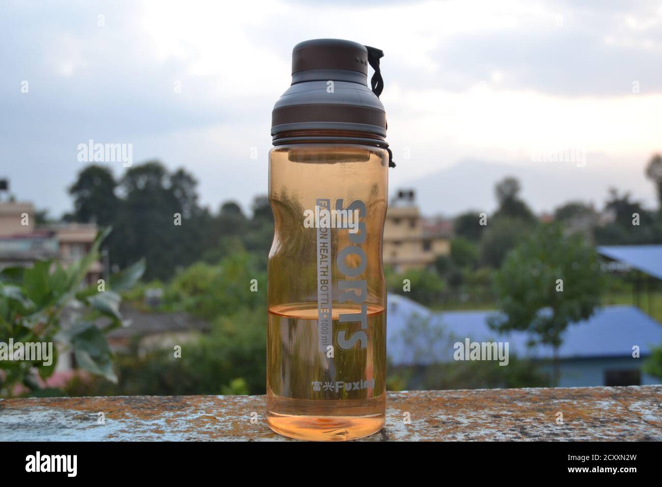 Water bottle with cloudy sky in the background. Stock Photo