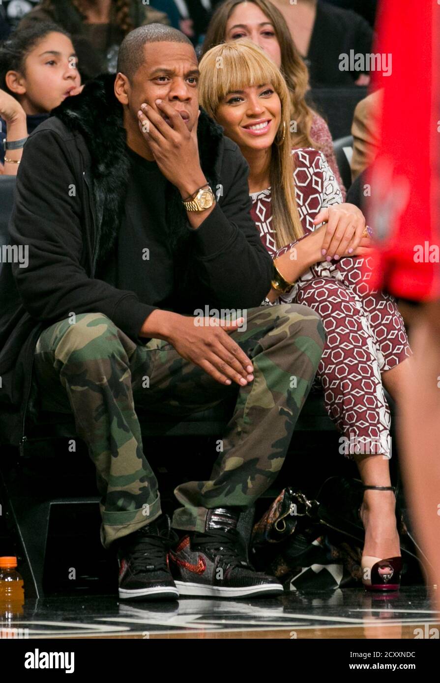 Entertainers Beyonce and Jay-Z watch the Brooklyn Nets play the Toronto  Raptors in the fourth quarter of their NBA basketball game in New York,  November 3, 2012. REUTERS/Ray Stubblebine (UNITED STATES -