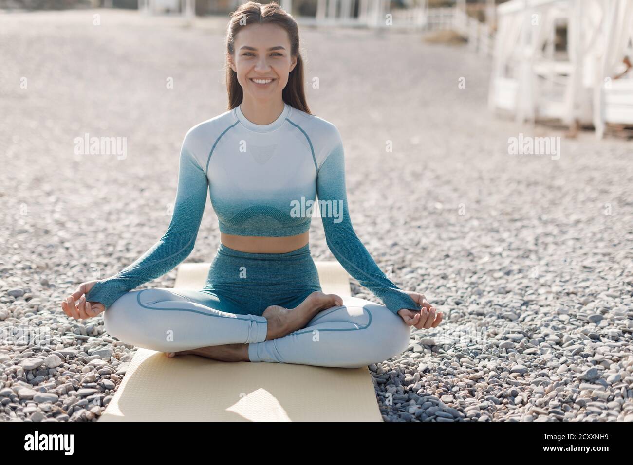 Caucasian young woman practicing yoga at seashore Stock Photo - Alamy