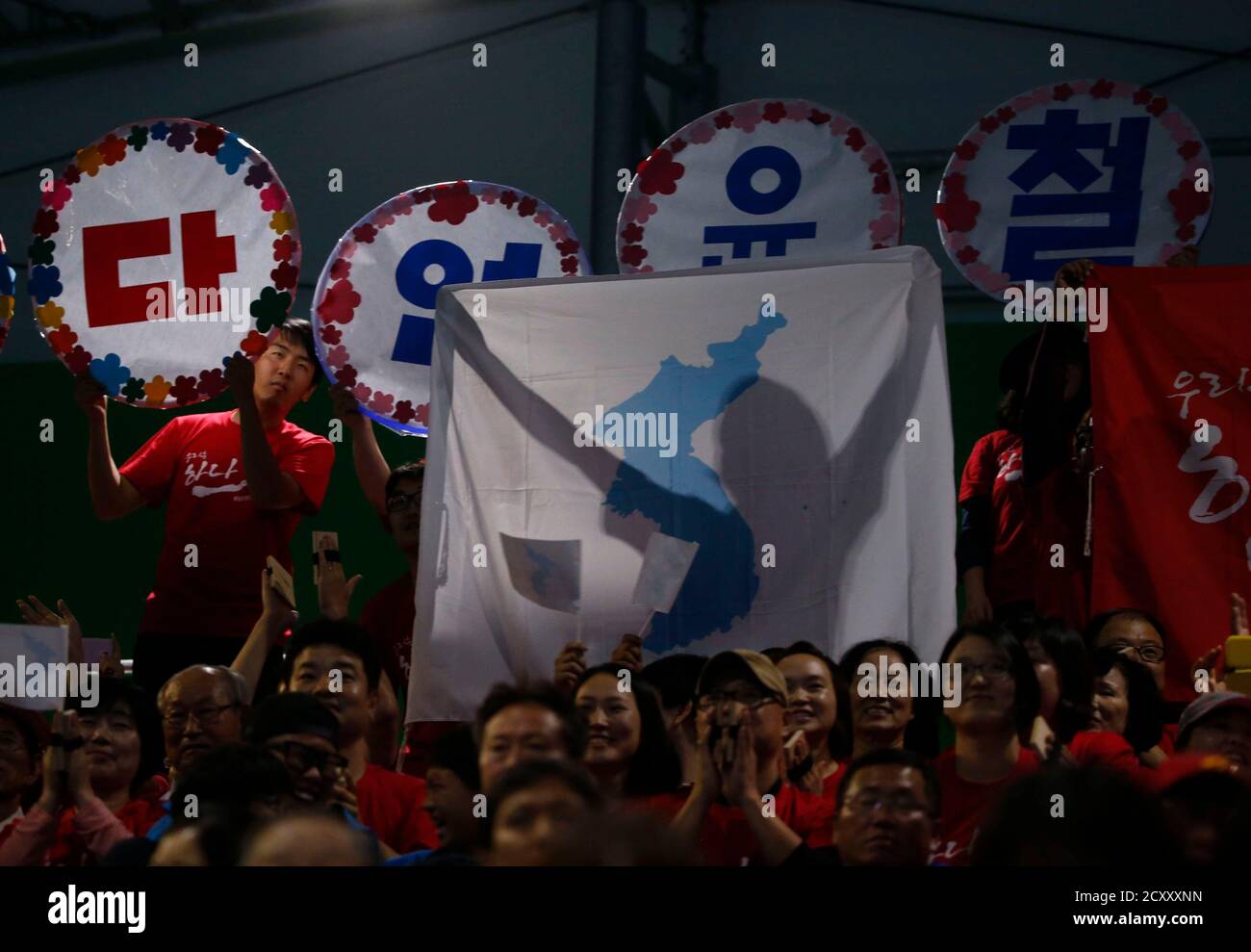A sports fan holds up a map of North and South Korea as one land mass after North Korea's Om Yun Chol won the gold medal in the men's 56kg weightlifting competition at the Moonlight Festival Garden during the 17th Asian Games in Incheon September 20, 2014. Om broke his own clean and jerk world record on the way to winning his country's first gold medal of the Asian Games in Incheon on Saturday. The North Korean weightlifter who won a gold medal at the London Olympics, raised 170 kilograms to better his old record by 1kg in the men's 56kg class. He earlier lifted 128kg in the snatch for a combi Stock Photo