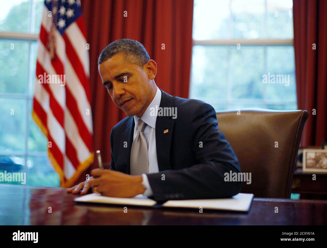 U.S. President Barack Obama signs a proclamation to designate federal lands within the former Fort Ord as a national monument under the Antiquities Act, in the Oval Office of the White House in Washington, April 20, 2012.   REUTERS/Jason Reed   (UNITED STATES - Tags: POLITICS) Stock Photo