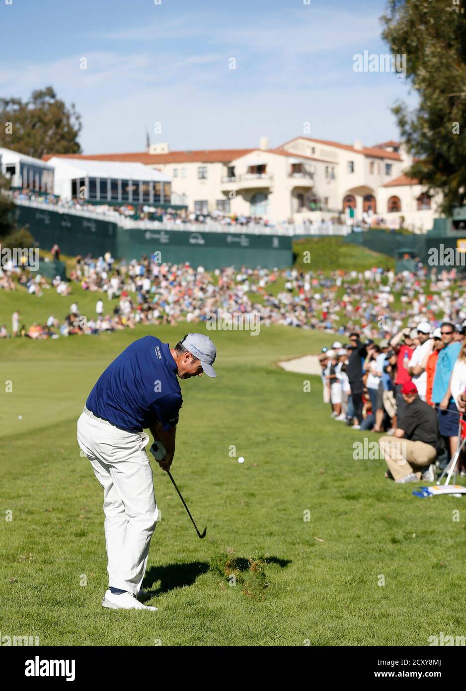 Matt Kuchar of the U.S. hits his approach from the rough on the 18th hole,  which struck a spectator sitting around the green below the clubhouse,  during the third round of the