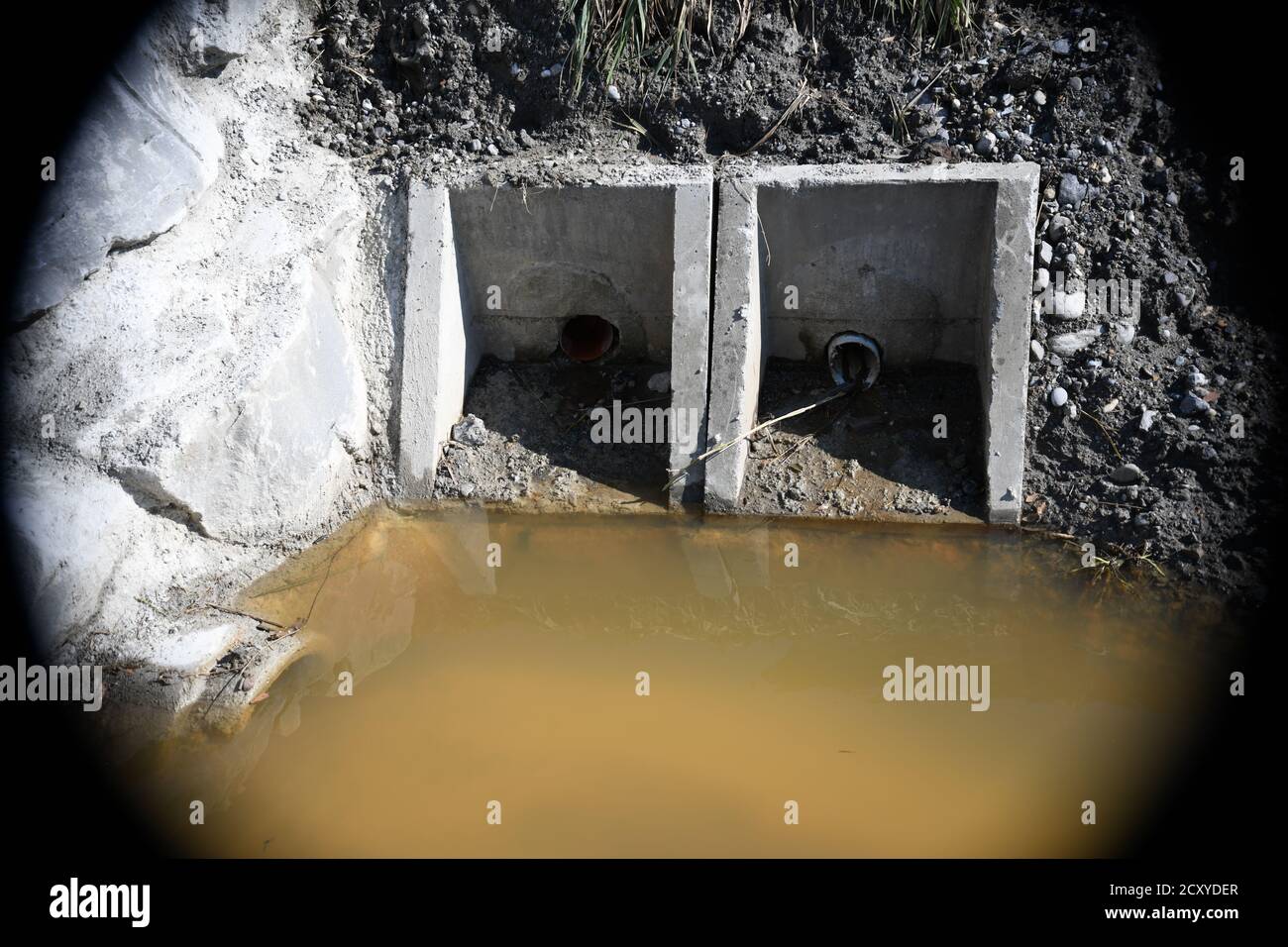 stehendes Wasser vor Kanalrohr auf einer Baustelle Stock Photo