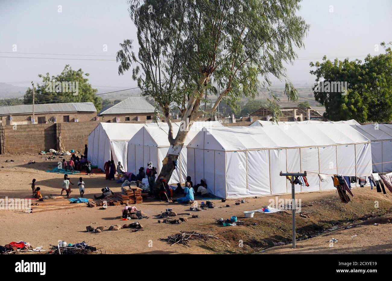 People displaced as a result of Boko Haram attacks in the northeast region of Nigeria, are seen near their tents at a faith-based camp for internally displaced people (IDP) in Yola, Adamawa State January 14, 2015. Boko Haram says it is building an Islamic state that will revive the glory days of northern Nigeria's medieval Muslim empires, but for those in its territory life is a litany of killings, kidnappings, hunger and economic collapse. Picture taken January 14. To match Insight NIGERIA-BOKOHARAM/     REUTERS/Afolabi Sotunde (NIGERIA - Tags: CIVIL UNREST SOCIETY) Stock Photo