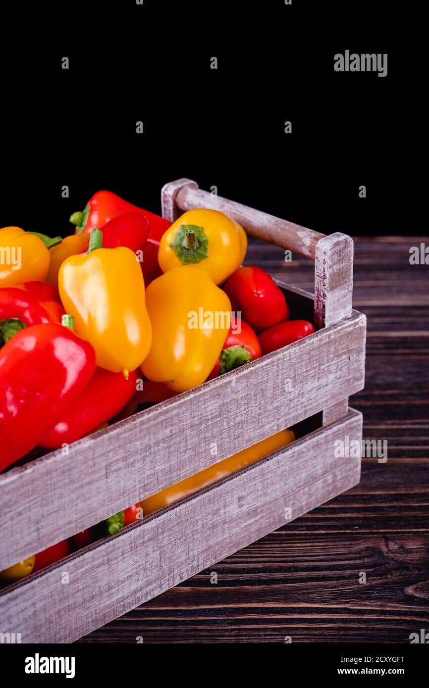 Fresh colored bell peppers on a rustic wooden background. Stock Photo