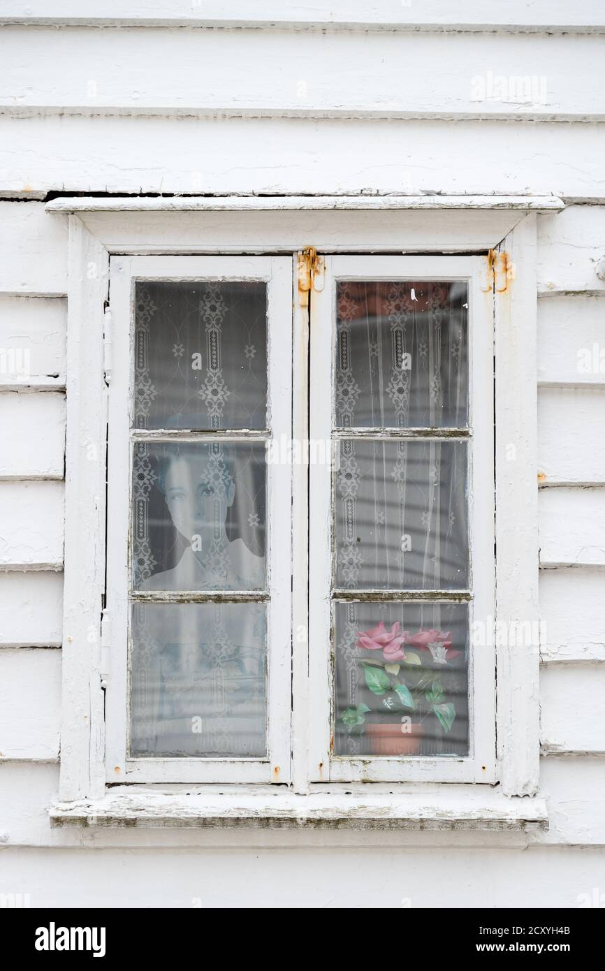 SKUDENESHAVN, NORWAY - 2018 JULY 05. White old charming window with photo of a woman inside the window, Stock Photo