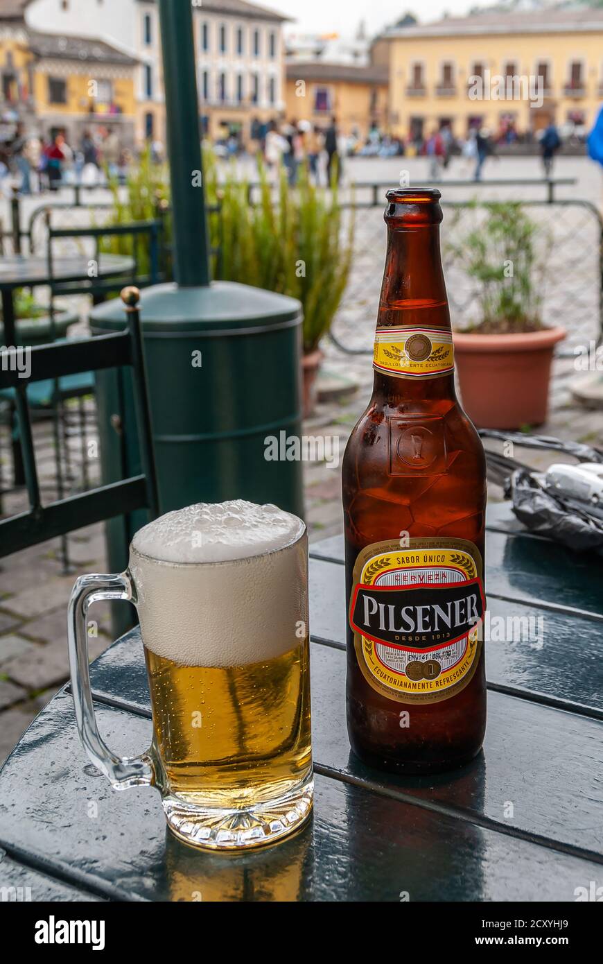 Quito, Ecuador - December 2, 2008: Historic downtown. Closeup of bottle and glass filled with Pilsener local brand beer, standing on black table. Fade Stock Photo