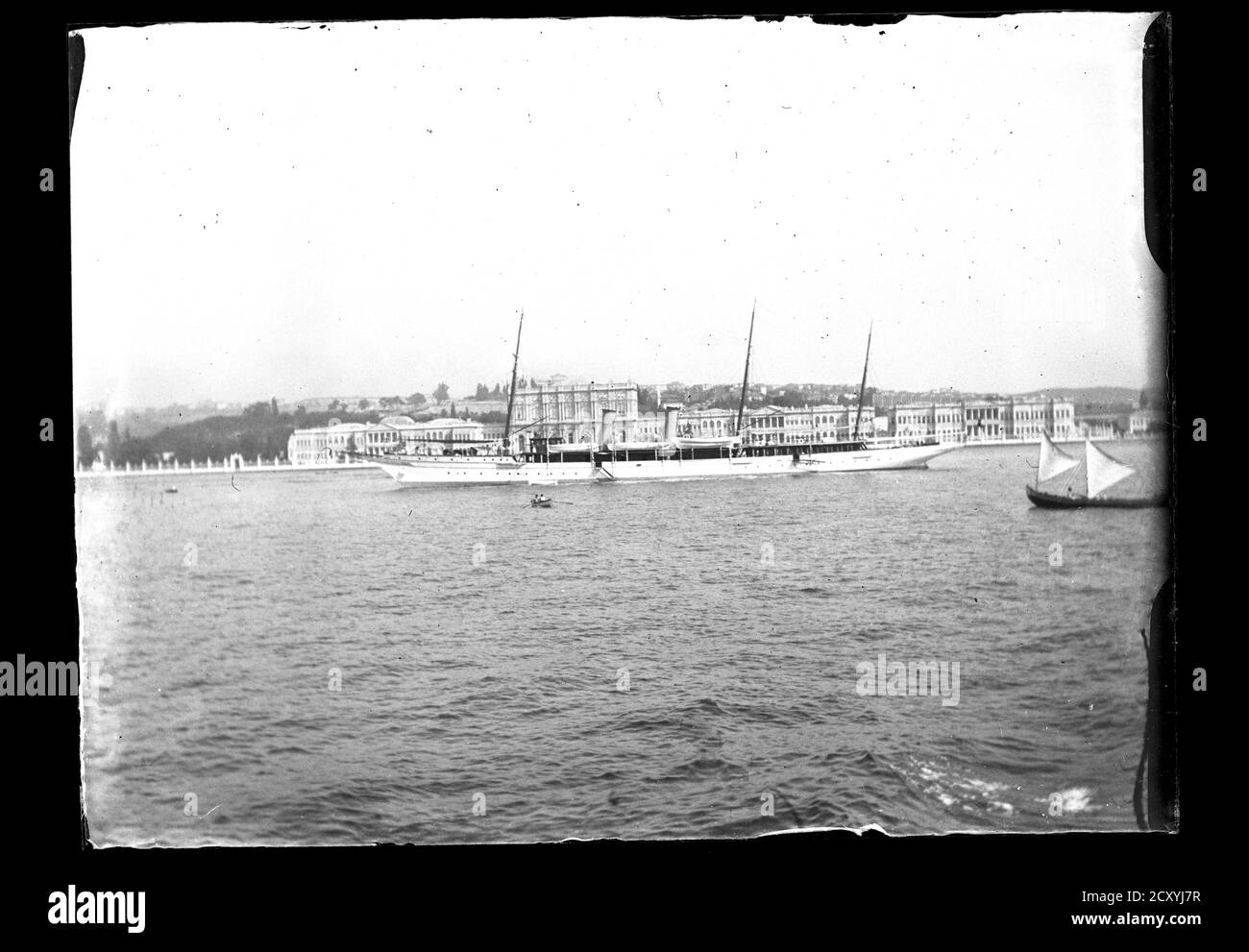 Turkey Istanbul Golden Horn Ottoman Imperial yacht Ertuğrul passing Dolmabahçe Palace. The Imperial Ottoman Government used many yachts for its head of state. Others were: Tesrifiye, İzzeddin, Sultaniye and Talia. Photograph on dry glass plate from the Herry W. Schaefer collection, around 1910. Stock Photo