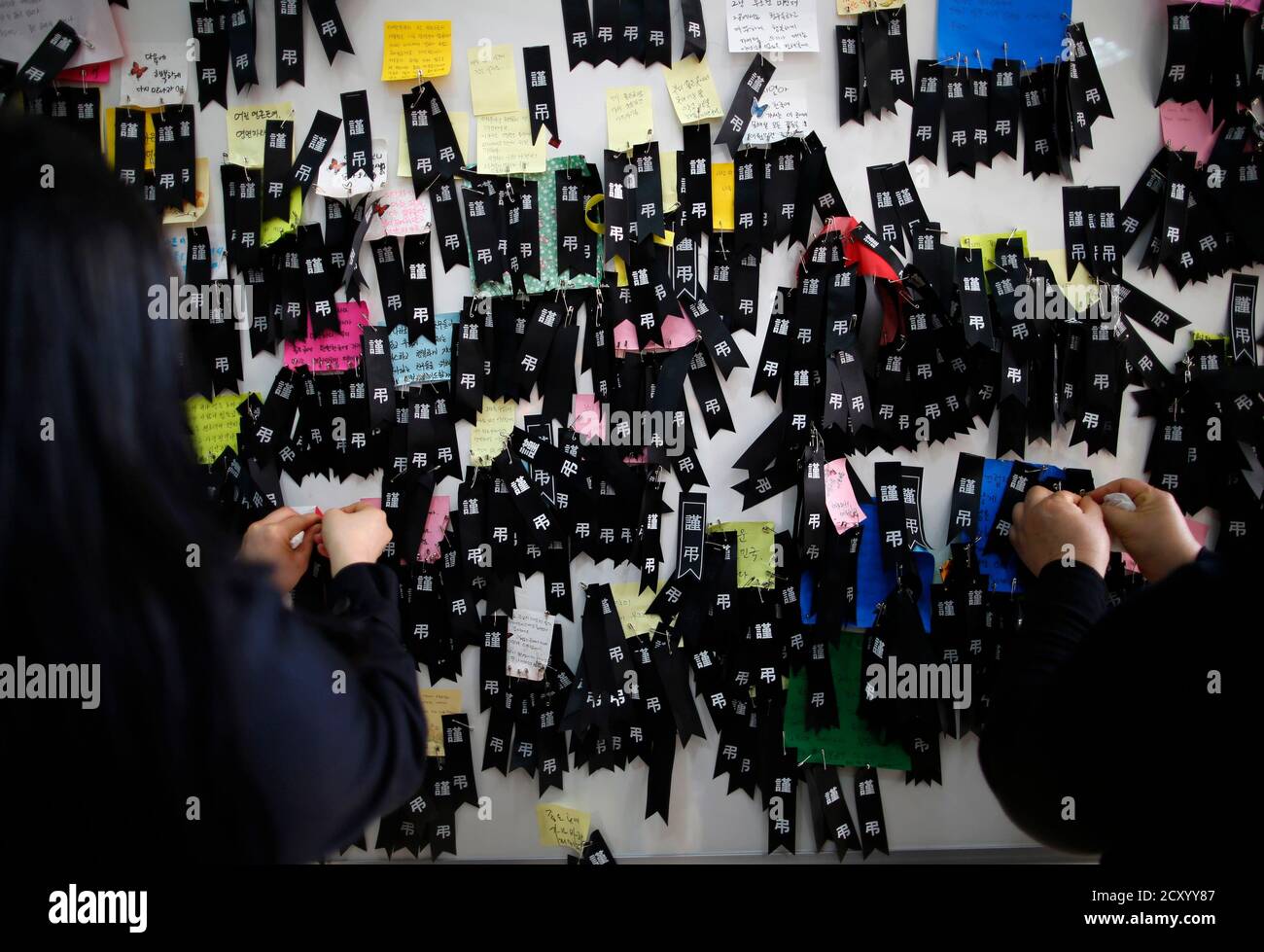 Mourners place black mourning ribbons next to messages for victims of the capsized passenger ship Sewol in Ansan, at a temporary group memorial altar for the victims, April 25, 2014. The Sewol ferry, weighing almost 7,000 tons, sank on a routine trip from the port of Incheon, near Seoul, to the southern holiday island of Jeju. Investigations are focused on human error and mechanical failure. REUTERS/Issei Kato (SOUTH KOREA - Tags: DISASTER MARITIME) Stock Photo