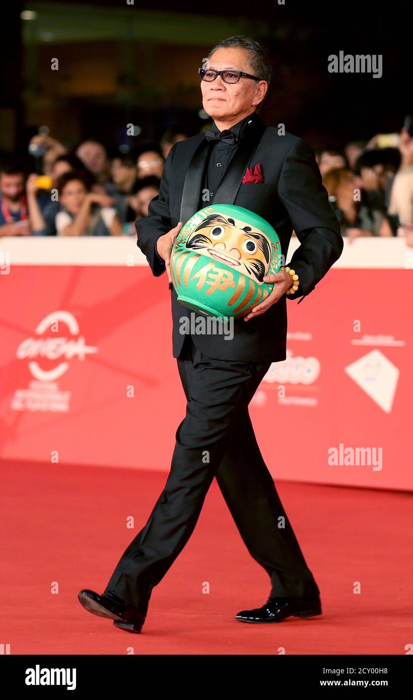 Director Takashi Miike Arrives Holding A Daruma Doll During The Red Carpet Event For The Movie Kamisama No Iutoori As The Gods Will At The Rome Film Festival October 18 2014 Reuters Alessandro