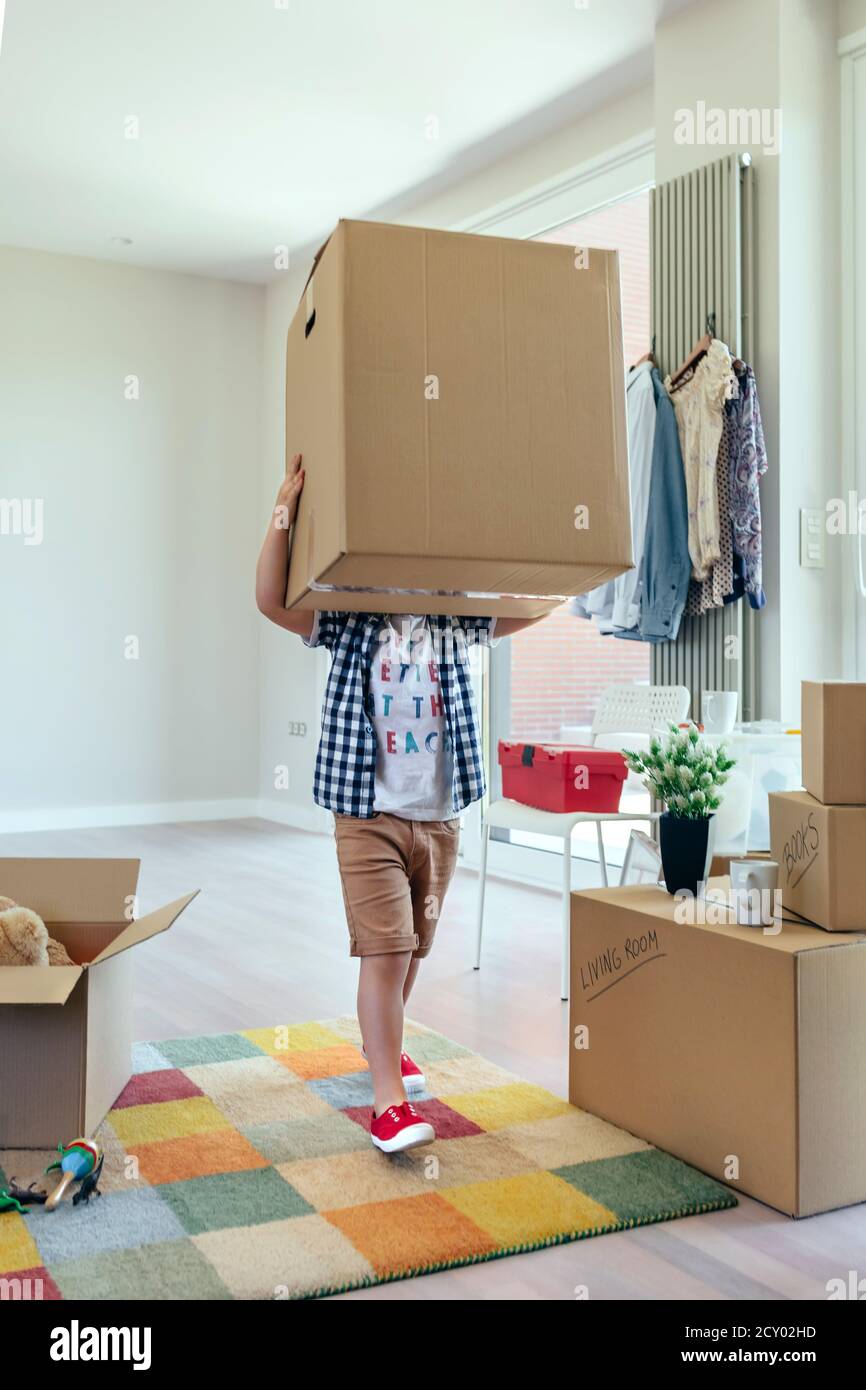 Boy carrying very large moving box Stock Photo