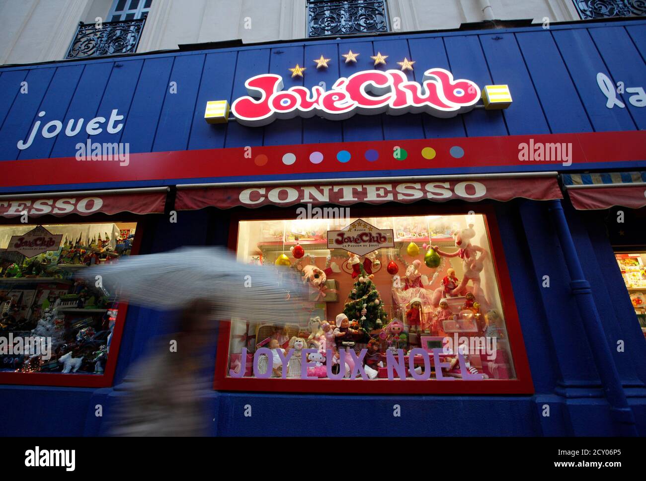 A person with an umbrella passes by a Christmas display in the window of  Contesso JoueClub toy shop in Nice, southeastern France, December 2, 2011.  Picture taken December 2, 2011. REUTERS/Eric Gaillard (