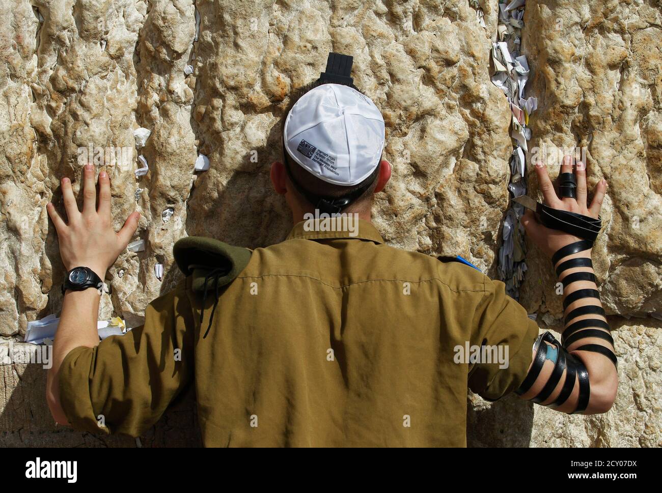 An Israeli soldier wears phylacteries as he prays at the Western Wall, Judaism's holiest prayer site, in Jerusalem's Old City February 22, 2012. The Israeli Defence Force (IDF) has always been a 'Jewish' army. Its rations are kosher, its chaplains are rabbis, and it operates - with the exception of wartime - around the festival calendar. It has never drafted soldiers from Israel's 20-percent Arab minority. But its Jewish identity has always been more cultural than religious. IDF personnel data suggests that's changing. Around 57 percent of Israel's Jewish majority, census figures show, define  Stock Photo