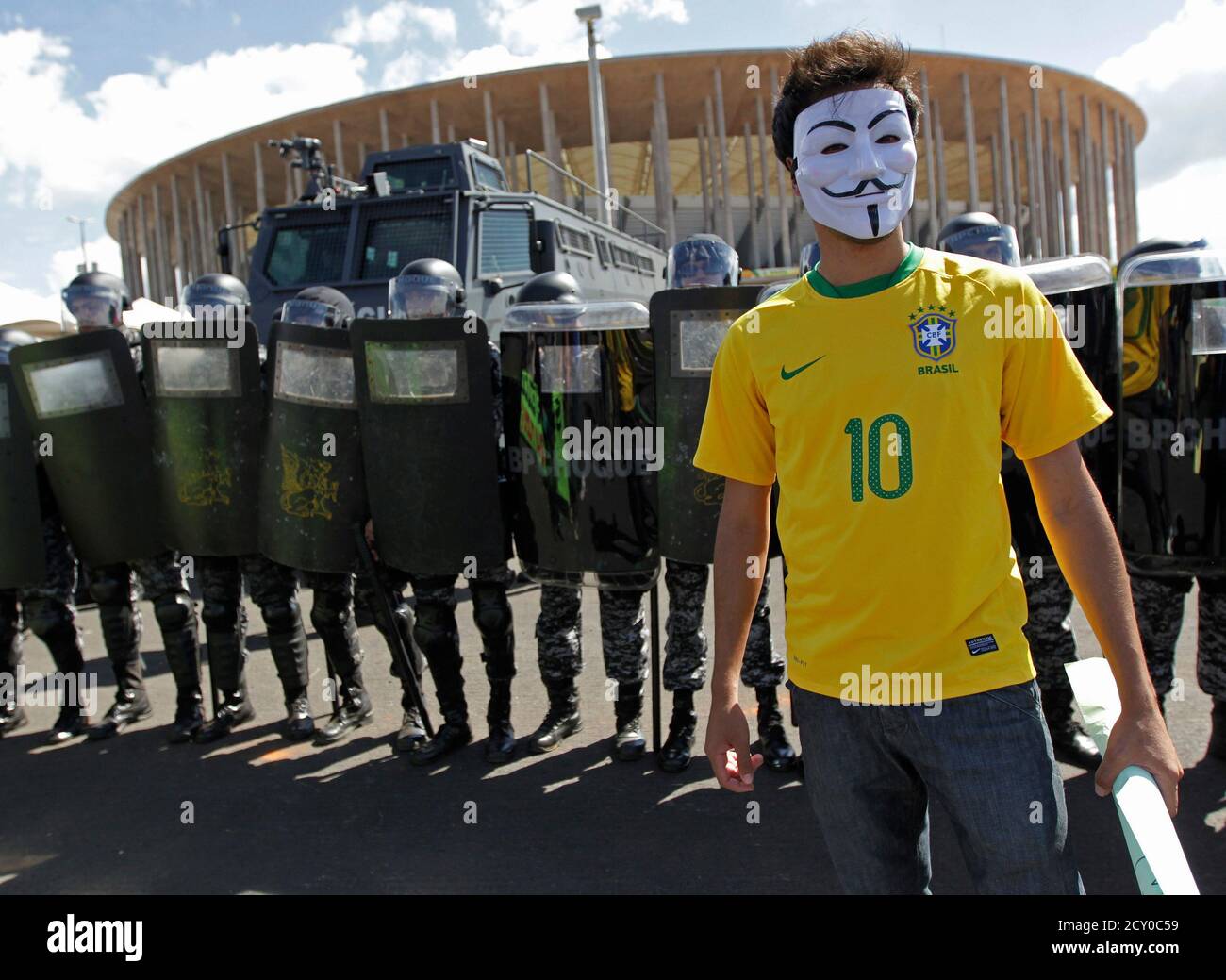 An activist demonstrates in front of riot police outside the Mane Garrincha  National Stadium in Brasilia June 15, 2013. Protests continued in Brasilia  over the government's economic policies and the hosting of
