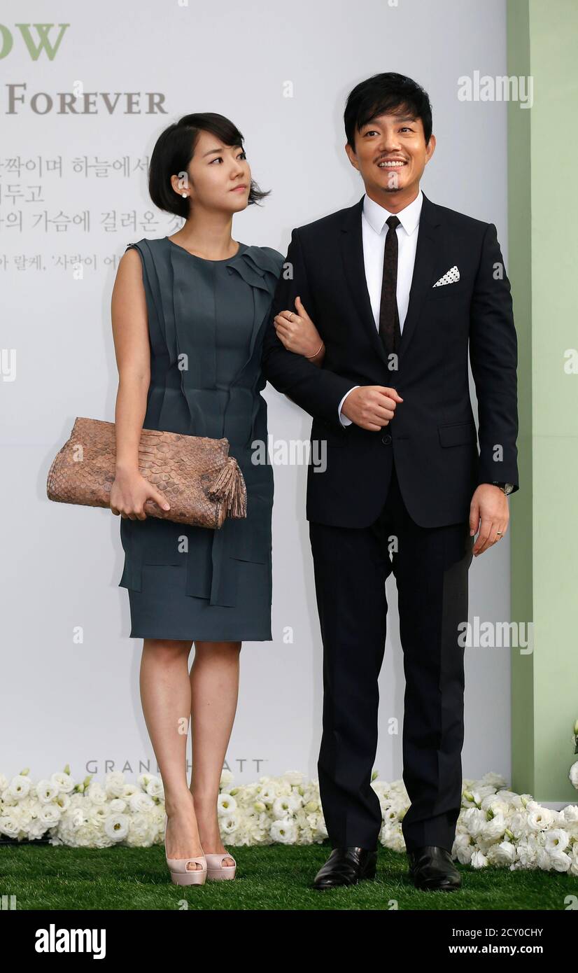 South Korean actor Lee Bum-soo (R) and his wife Lee Yun-jun pose for  photographs as they arrive for the wedding ceremony of South Korean actor  Lee Byung-hun and actress Lee Min-jung at