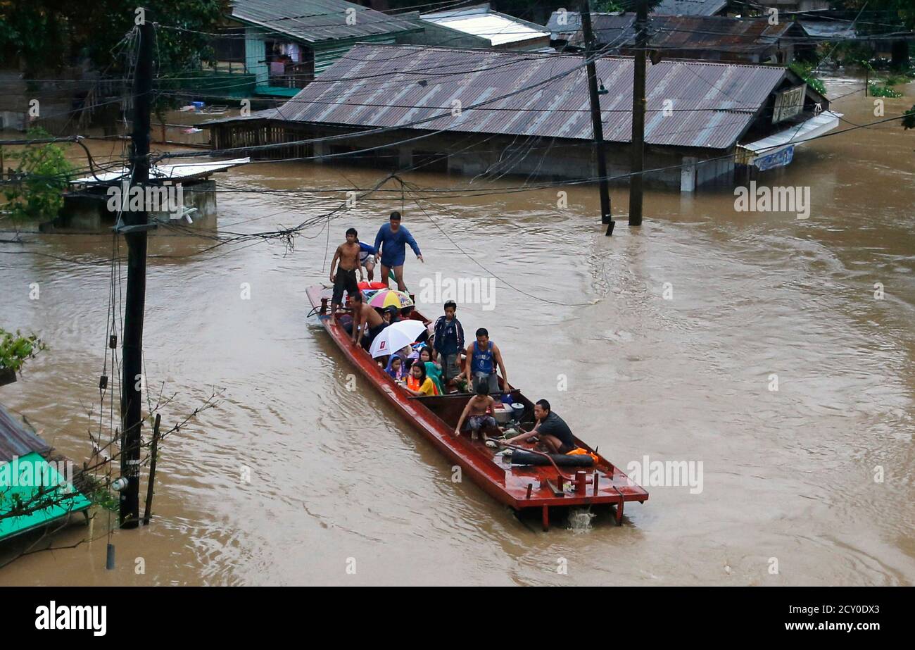 Flood victims ride on a rescue boat after bring evacuated from heavy flooding brought by tropical depression 'Agaton' in Butuan in the southern Philippine island of Mindanao January 20, 2014. Floods and landslides caused by tropical depression 'Agaton'  have killed 40 people and more than 500,000 people are displaced in Mindanao, the National Disaster Risk Reduction and Management Council reported on Sunday.   REUTERS/Erik De Castro (PHILIPPINES - Tags: DISASTER ENVIRONMENT) Stock Photo
