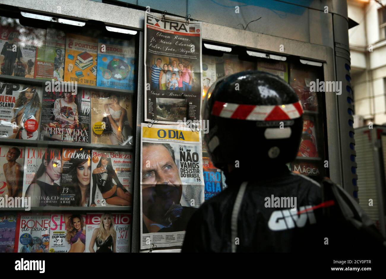A man reads newspapers announcing the death of the late presidential candidate Eduardo Campos, in Rio de Janeiro August 14, 2014. Brazilian environmentalist Marina Silva is still in shock from the death of Campos and has not begun to consider whether she will run in his place, a close friend said on Thursday. That closely watched decision could upend the Oct. 5 presidential race and threaten President Dilma Rousseff's re-election bid, given Silva's appeal to disaffected voters tired of the country's traditional parties. REUTERS/Pilar Olivares (REUTERS - Tags: POLITICS ELECTIONS) Stock Photo