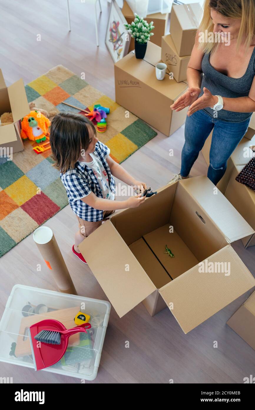 Mother and son unpacking moving box Stock Photo