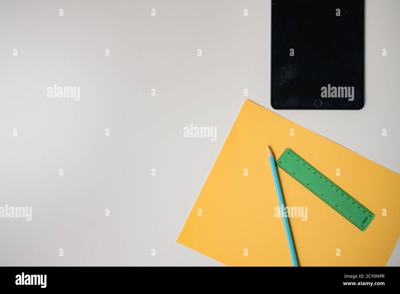 black tablet and school supplies on plain white table Stock Photo