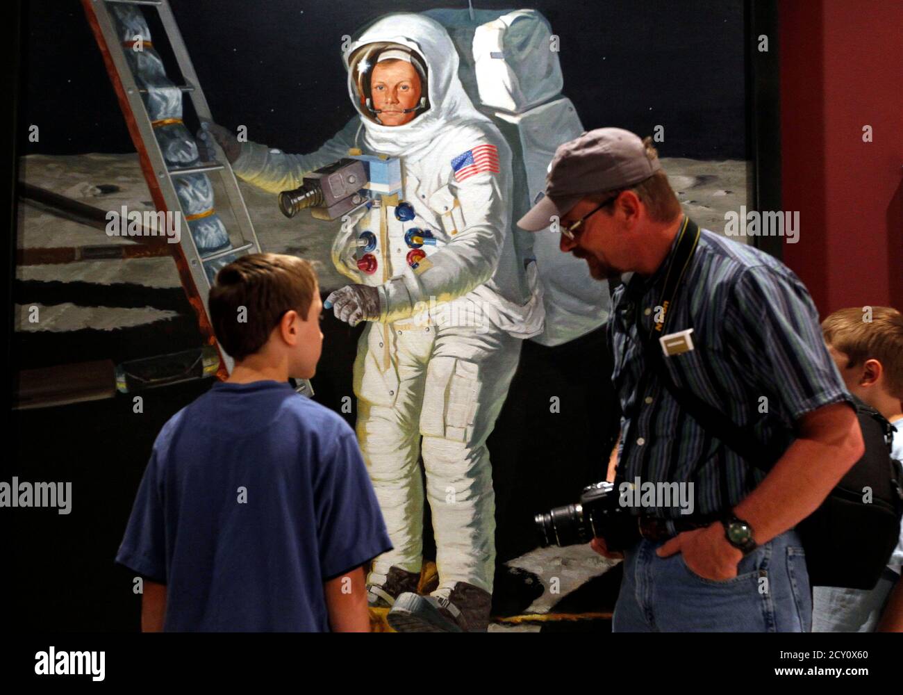 Kenny Wilson talks to his son Joshua (L) before a public memorial service for U.S. astronaut Neil Armstrong at the Armstrong Air and Space Museum in Wapakoneta, Ohio August 29, 2012.  Armstrong, who took a giant leap for mankind when he became the first person to walk on the moon, has died at the age of 82, his family said on Saturday.  REUTERS/Matt Sullivan  (UNITED STATES - Tags: SCIENCE TECHNOLOGY OBITUARY) Stock Photo
