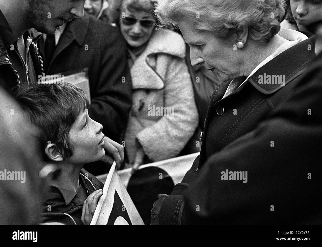 AJAXNETPHOTO.11TH FEBRUARY,1977. PORTSMOUTH, ENGLAND.  - CITY WALKABOUT - MRS MARGARET THATCHER (CON), LEADER OF THE OPPOSITION, CHATS WITH 11 YEAR OLD TONY VENN FOM PORTSEA WHILE MEETING THE PUBLIC IN COMMERCIAL ROAD SHOPPING PRECINCT DURING A CAMPAIGN WALKABOUT. PHOTO:JONATHAN EASTLAND/AJAX REF:3771102 43 Stock Photo