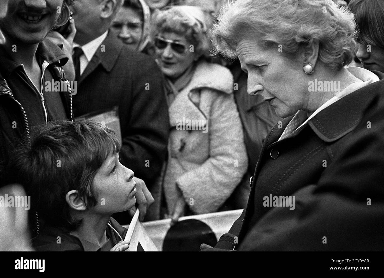 AJAXNETPHOTO.11TH FEBRUARY,1977. PORTSMOUTH, ENGLAND.  - CITY WALKABOUT - MRS MARGARET THATCHER (CON), LEADER OF THE OPPOSITION, CHATS WITH 11 YEAR OLD TONY VENN FOM PORTSEA WHILE MEETING THE PUBLIC IN COMMERCIAL ROAD SHOPPING PRECINCT DURING A CAMPAIGN WALKABOUT. PHOTO:JONATHAN EASTLAND/AJAX REF:3771102 44 Stock Photo