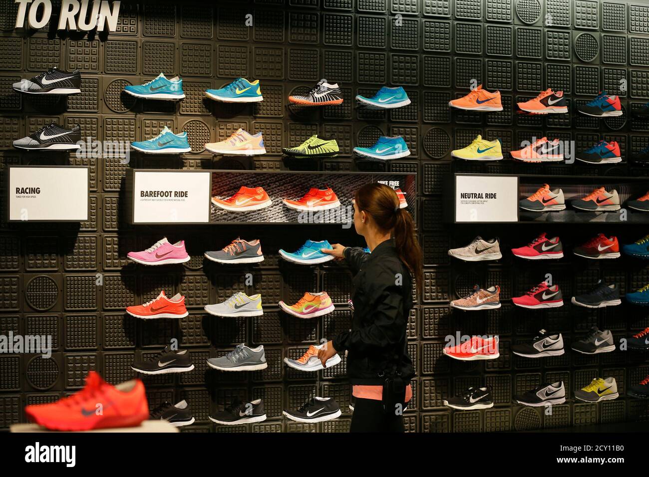 A woman picks up a shoe in the Nike store in Santa Monica, California,  September 25, 2013. NIKE, Inc. plans to release its first quarter fiscal  2014 financial results on Thursday, September