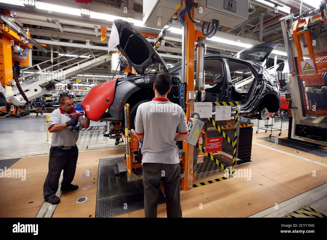 Workers assemble vehicles on the assembly line of the SEAT car factory in  Martorell November 12, 2013. While much of the European car industry is in  dire straits, Spanish assembly plants are