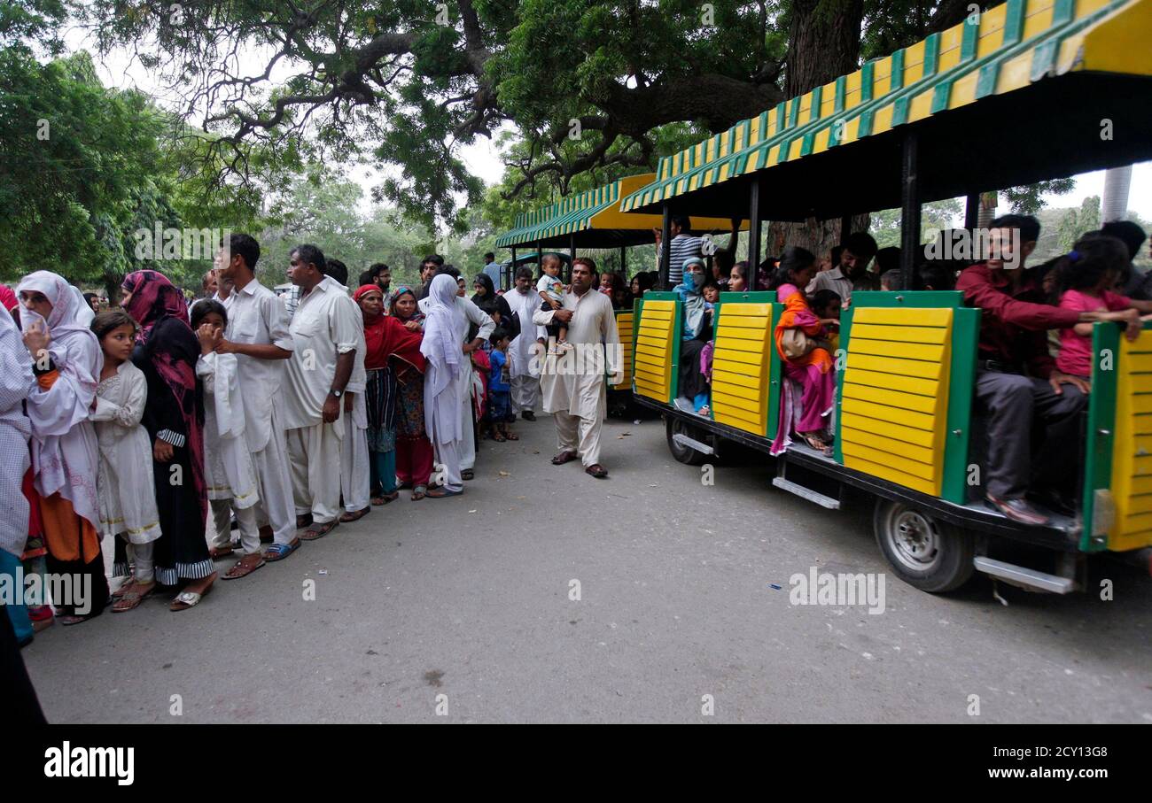 A tourist car moves past visitors standing in line outside Mumtaz Mahal (Mumtaz Palace), a small room where an entertainer performing as the character 'Mumtaz Begum' (not pictured), a fox-human hybrid creature, sits inside a wooden canopy to amuse visitors, at Karachi Zoo in Karachi June 22, 2014.  REUTERS/Akhtar Soomro (PAKISTAN - Tags: SOCIETY TRAVEL) Stock Photo