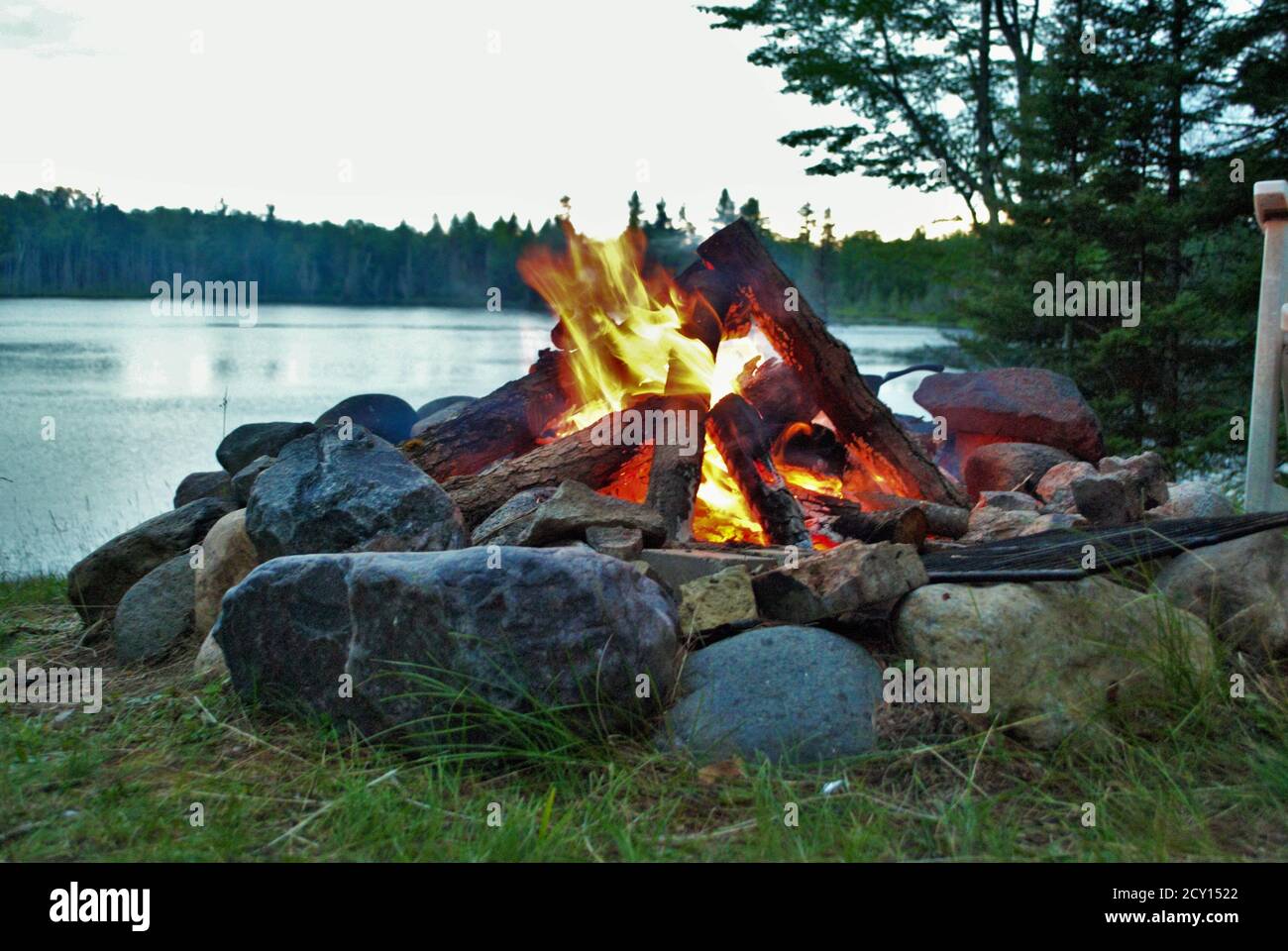 camp fire burning in a fire pit next to the lake Stock Photo Alamy