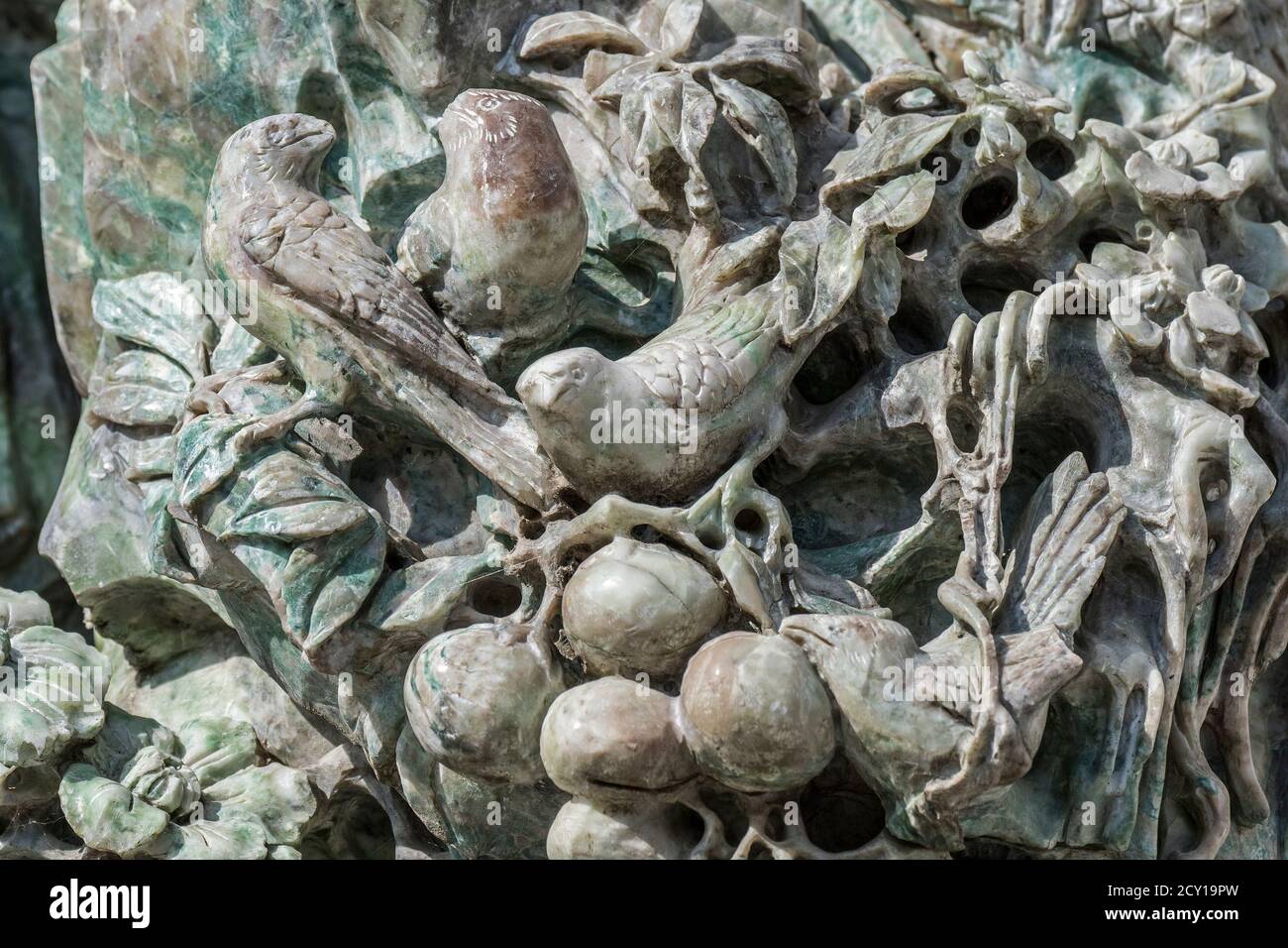 Close up of old Chinese statue showing sculpted birds made of jade, ornamental mineral Stock Photo