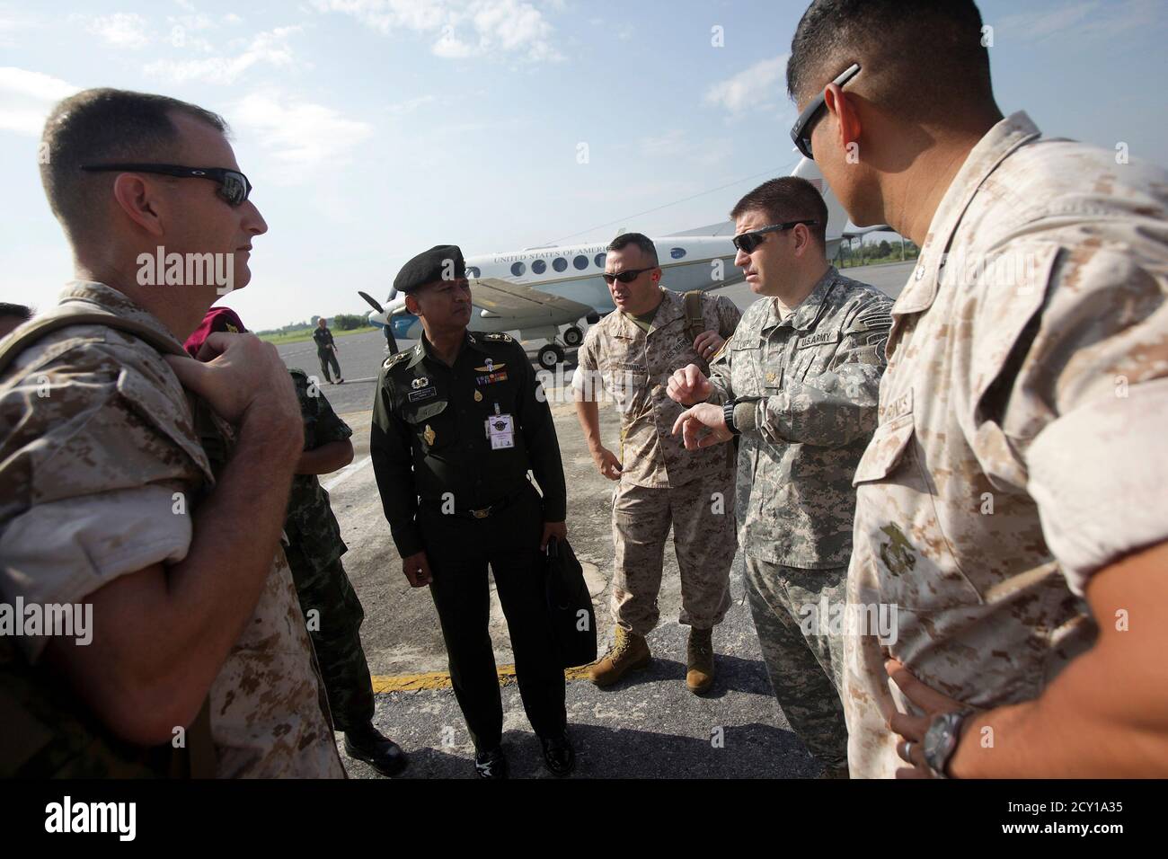 Colonel John A. Ostrowski (L), Lt Col. Bob Vietas (C), Lt Col. Michael Pelak (R) of the U.S. Marine Expeditionary Force and Major J.C. 'Lumpy' Lumbaca of the U.S. Army Special Forces (2nd R) talk to Thai Royal Army officers as they arrive in a military airport to view the flooding situation in Lopburi, central Thailand October 18, 2011. The group of U.S. marines arrived to Thailand to offer their assistance in coping with the worst flooding in 50 years that killed at least 315 people since July, damaged large areas of farmland and closed huge industrial estates this month.    REUTERS/Dario Pig Stock Photo