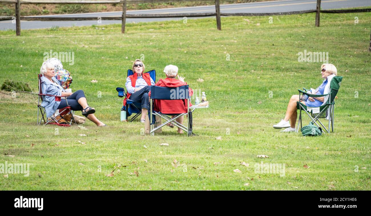 Berks County, Pennsylvania, September 24, 2020: Seniors sitting on lawn chairs social distancing in public park Stock Photo