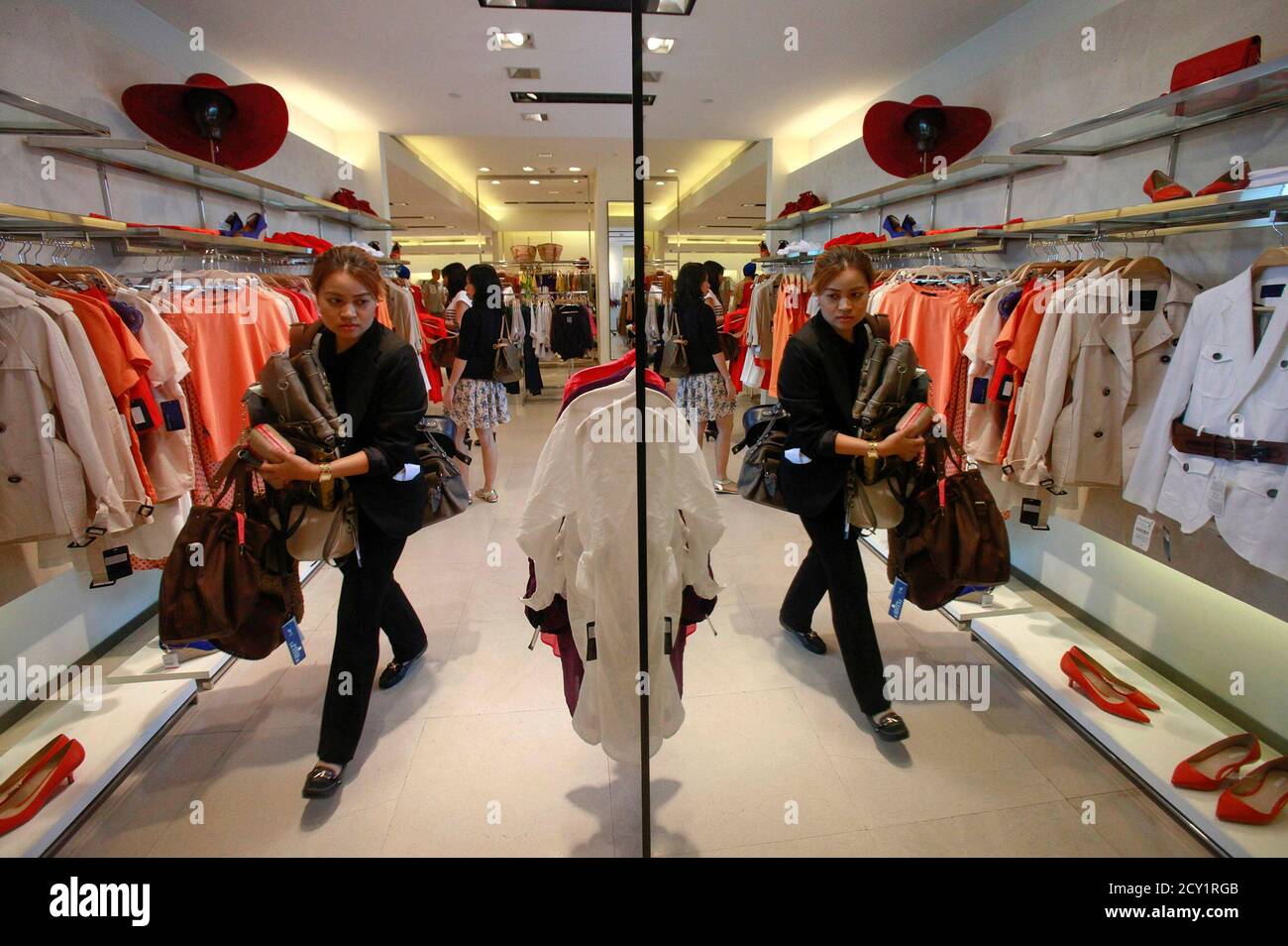 A woman carries clothes to try at a Zara shop in Siam Paragon shopping mall  in