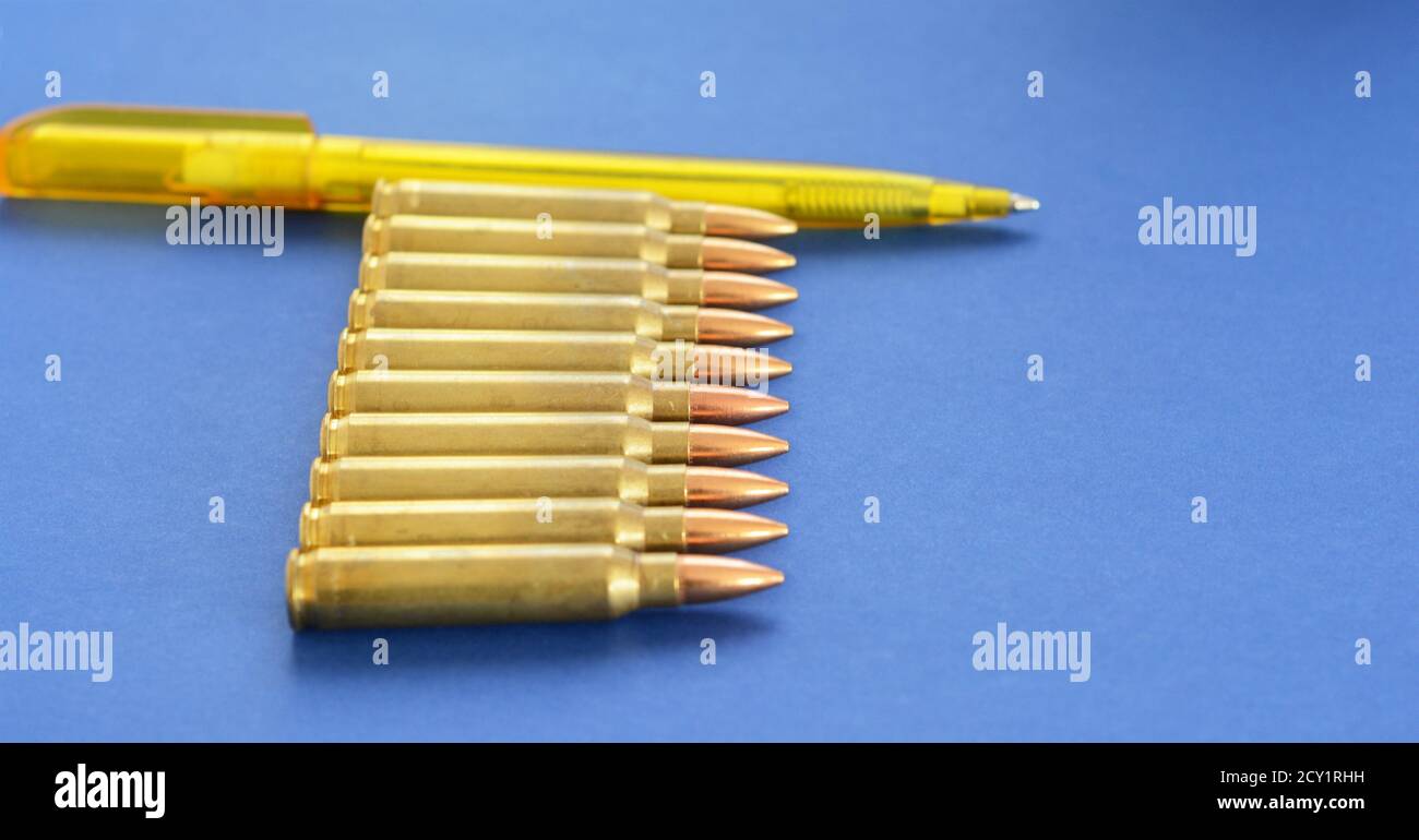 Military Cartridges  5.56mm Ammunition With a Pen as a Concept of Propaganda in Mass Media. Fake News Invasion Concept. Ukraine Crisis. Syria War. Stock Photo