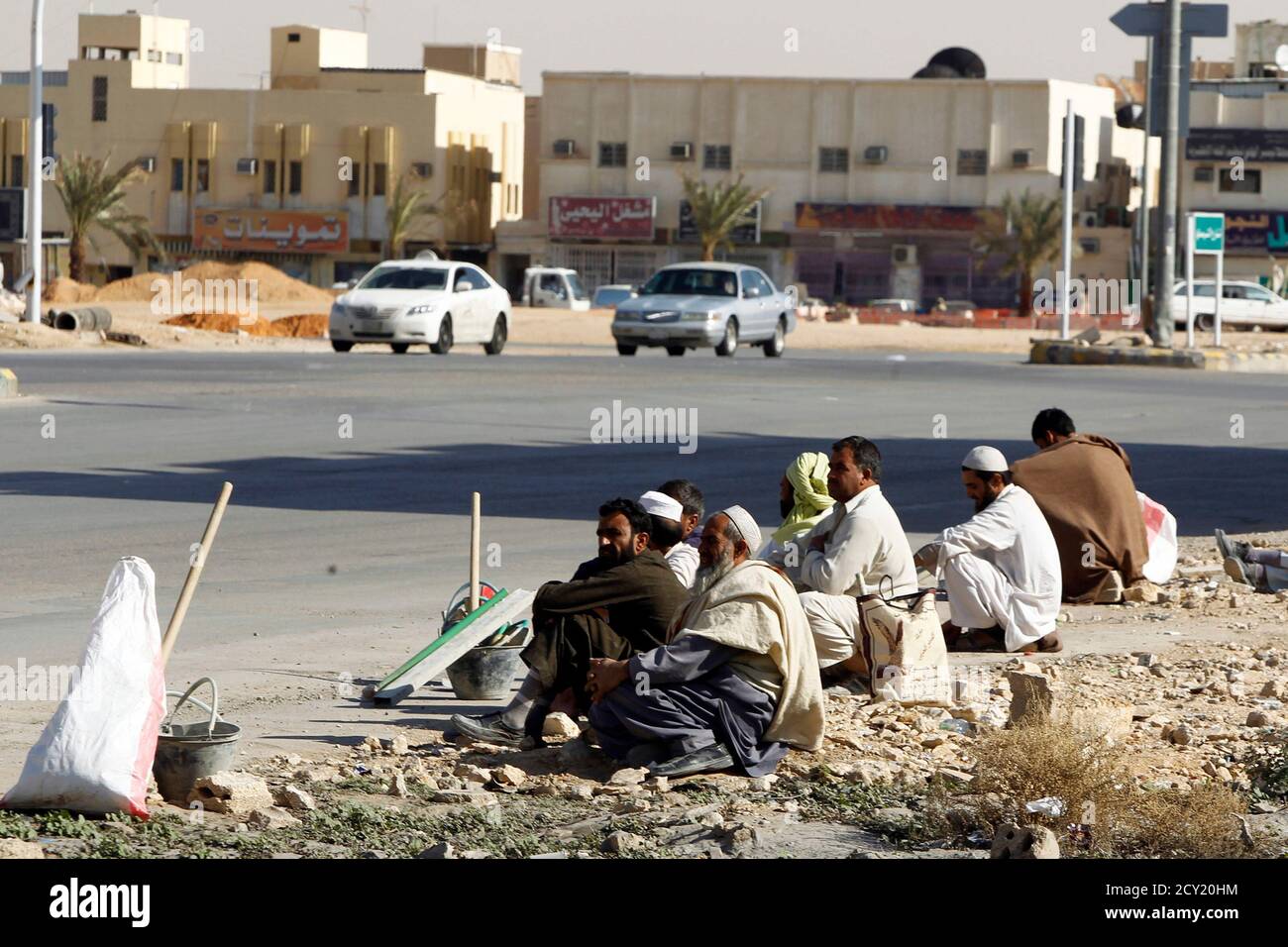 foreign construction labourers rest on a street in riyadh december 3 2012 in the latest and most aggressive of a series of labour reforms the government has started imposing fees on companies
