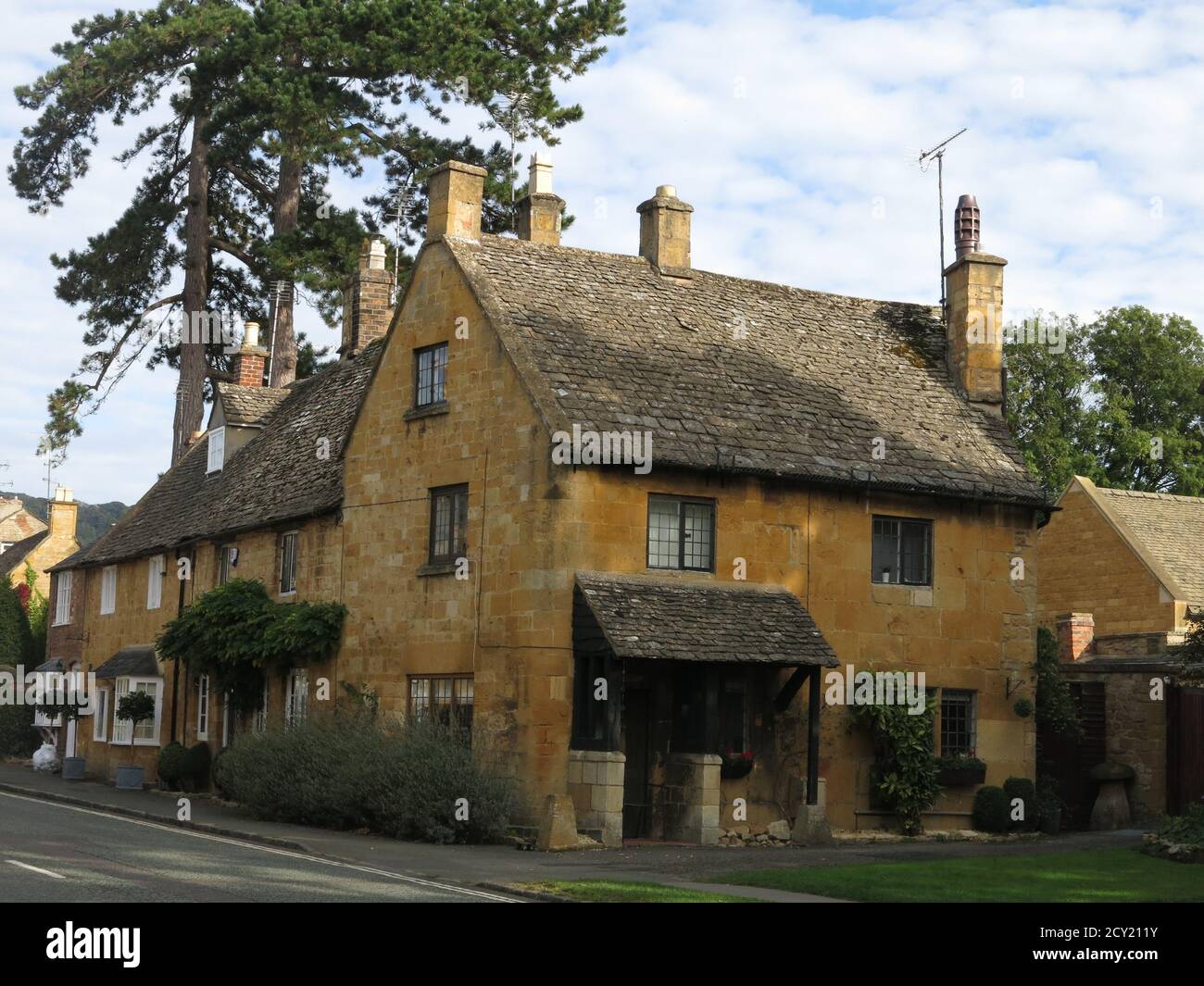 The High Street in the Cotswold village of Broadway is lined with traditional houses and cottages, built from the local honey-coloured stone. Stock Photo