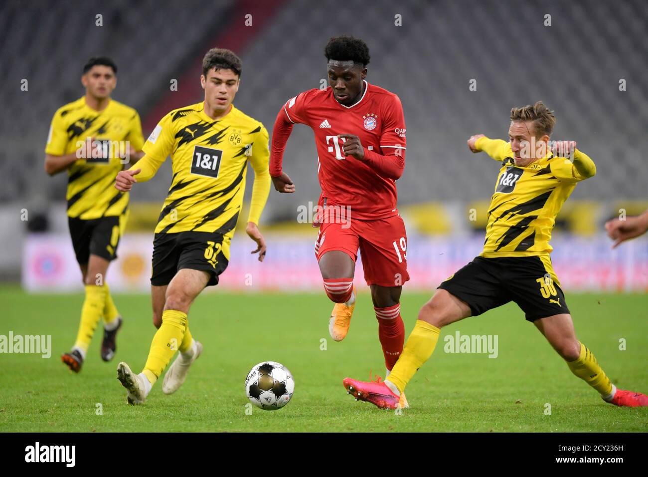 30.09.2020, Fussball DFL-Supercup 2020,  FC Bayern München - Borussia Dortmund, in der Allianz-Arena München. from left: Giovanni Reyna (Dortmund), Alphonso Davies (FC Bayern München), Felix Passlack (Dortmund).   Foto: Bernd Feil/M.i.S./Pool  Nur für journalistische Zwecke! Only for editorial use!  Gemäß den Vorgaben der DFL Deutsche Fußball Liga ist es untersagt, in dem Stadion und/oder vom Spiel angefertigte Fotoaufnahmen in Form von Sequenzbildern und/oder videoähnlichen Fotostrecken zu verwerten bzw. verwerten zu lassen. DFL regulations prohibit any use of photographs as image sequences a Stock Photo