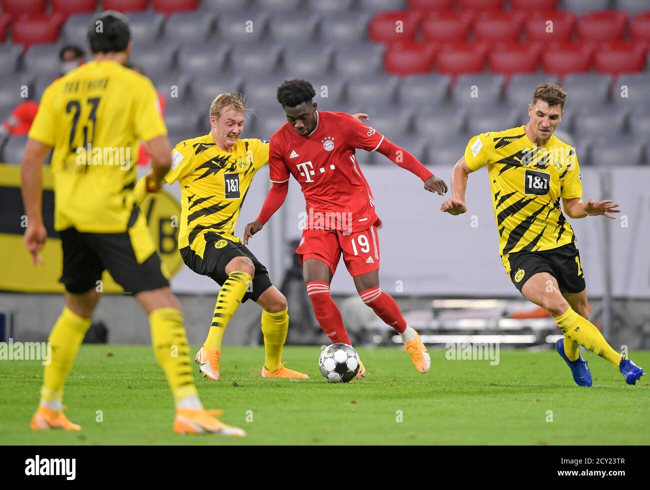 Allianz Arena Munich Germany 30.09.20, Football: German SUPERCUP FINALE 2020/2021, FC Bayern Muenchen (FCB, red) vs Borussia Dortmund (BVB, yellow) 3:2 —from left: Julian Brandt (Borussia Dortmund) gegen Alphonso Davies (Bayern München) und Thomas Meunier (Borussia Dortmund)   Foto: Bernd Feil/M.i.S./Pool/via Kolvenbach   Only for editorial use!  DFL regulations prohibit any use of photographs as image sequences and/or quasi-video.     National and international NewsAgencies OUT. Stock Photo
