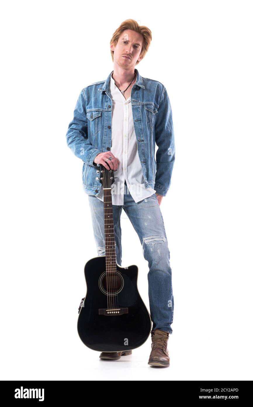 Macho serious young man in jeans looking at camera with guitar. Full body isolated on white background. Stock Photo