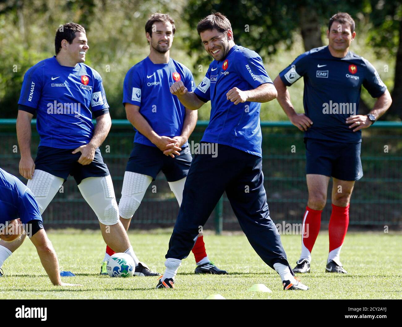 France S National Rugby Team Head Coach Marc Lievremont R Looks At His Players Stretch During A Training Session At Le Chambon Sur Lignon July 15 2011 In Preparation For The Upcoming 2011