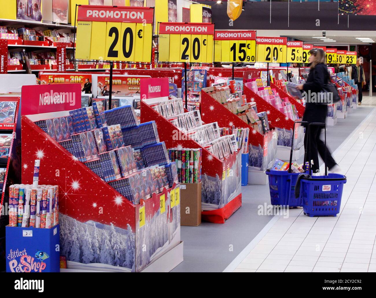 A customer shops near discount signs at Carrefour Planet supermarket in  Nice Lingostiere November 29, 2011. Consumer confidence in the 27-nation  European Union (EU) sunk to its lowest level this year in