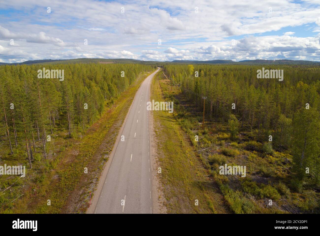 Aerial view of a road through sparsely populated forest landscape in northern Europe. Stock Photo