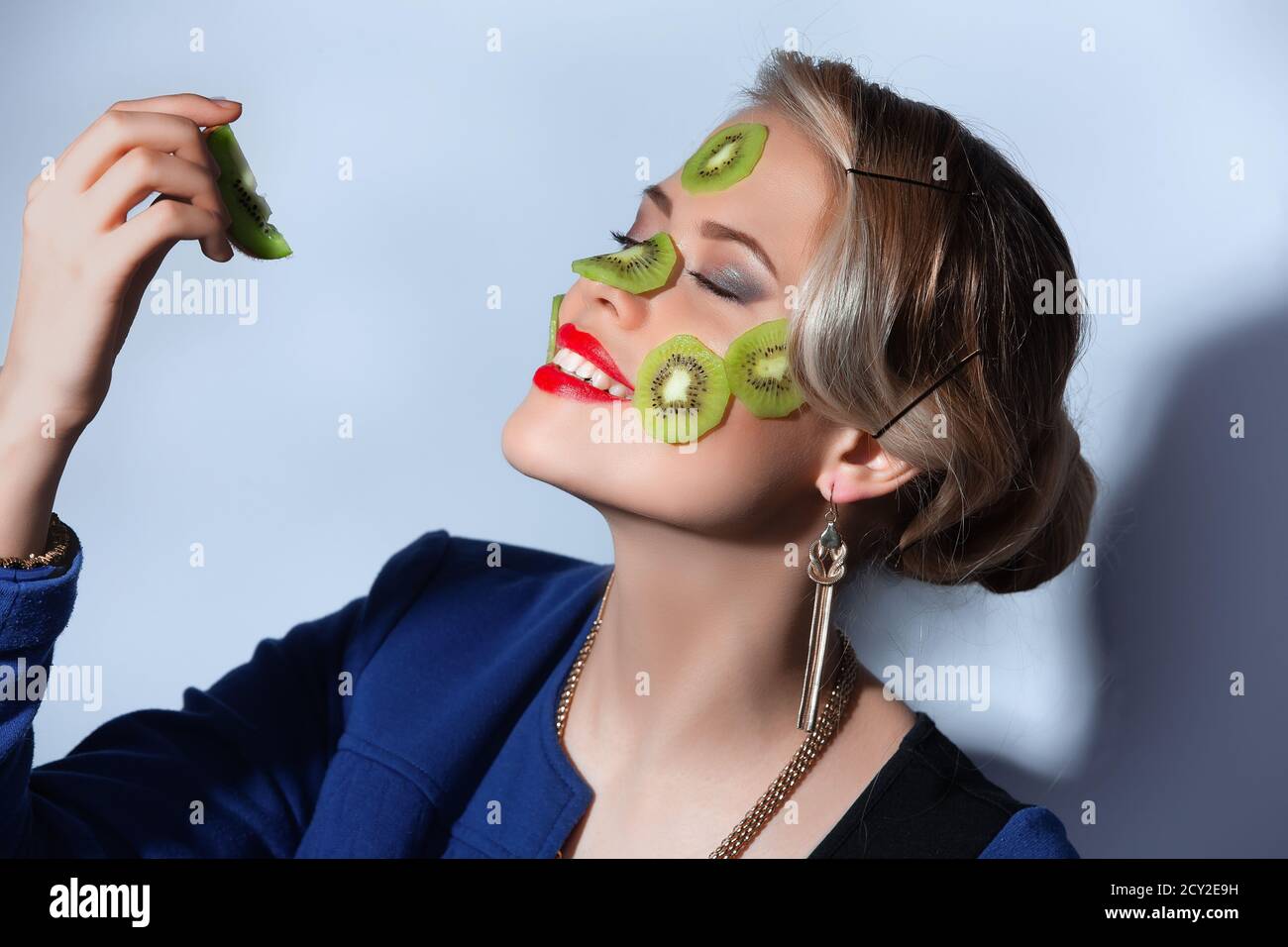 Fashion photo of woman posing with slices of kiwi on her face Stock ...