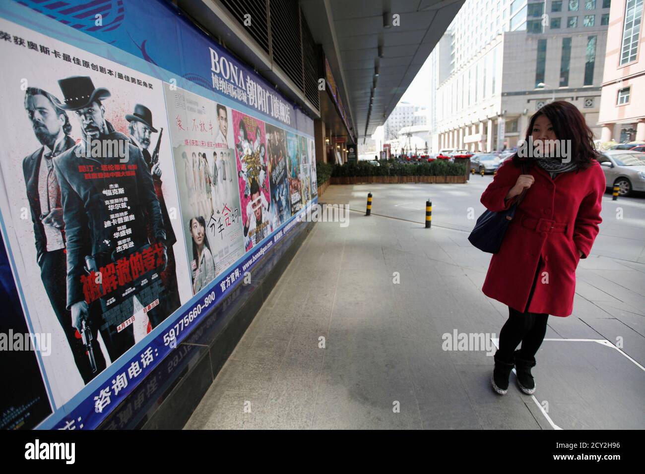 A woman looks at a poster of the film "Django Unchained" outside a cinema  in Beijing, April 11, 2013. The Chinese debut of Quentin Tarantino's  Oscar-winning film "Django Unchained", a violent Western