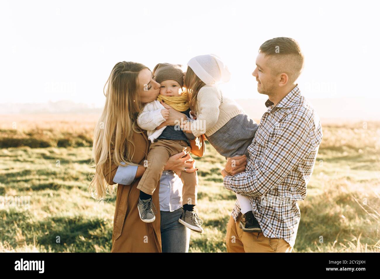 happy family playing in the green field at sunset Stock Photo