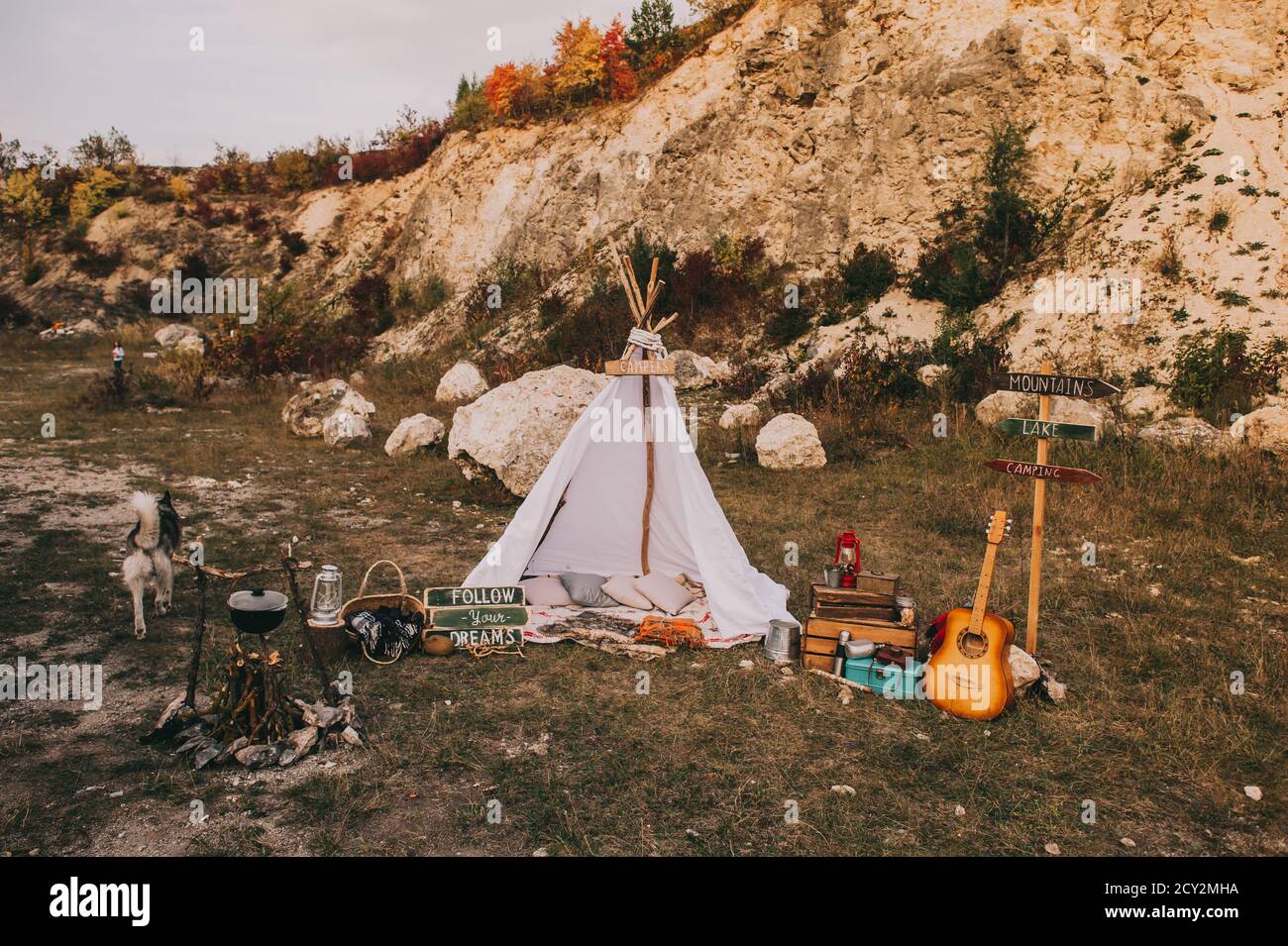 Autumn boho scenery with wigwam and vintage outdoor decor near the mountains. Stock Photo